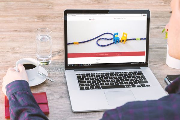 Business desk with laptop, coffee, and checklist for ecommerce store maintenance